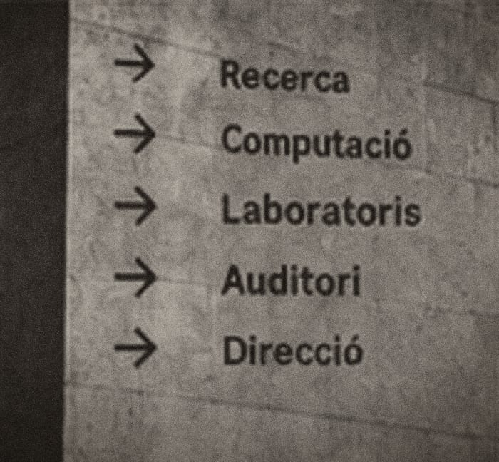 Rètol interior amb fletxes cap a Recerca, Computació, Laboratoris, Auditori i Direcció