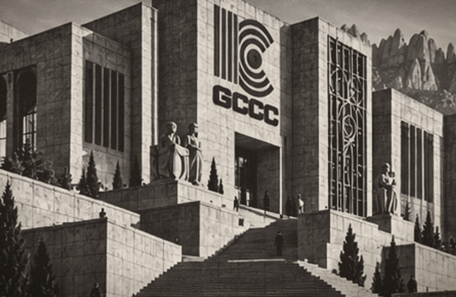 Seu central del GCCC: escalinata, arcades, xiprers i retolació, amb Montserrat al fons